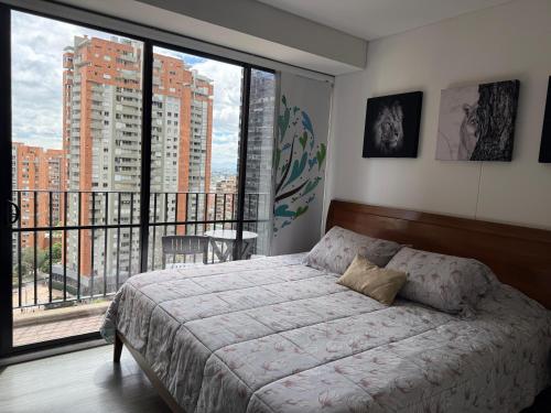 a bedroom with a bed and a large window at Loft Cool Equilibrium in Bogotá