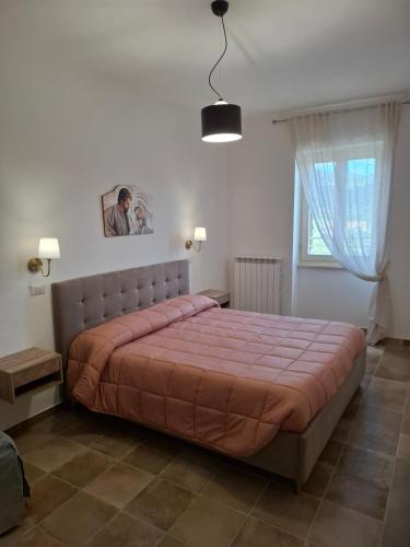 a bedroom with a large bed and a window at Domus Cassia in Cascia