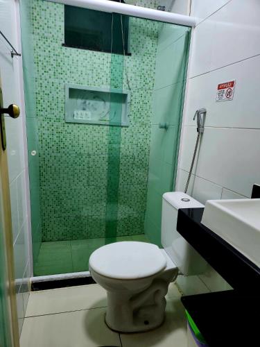 a bathroom with a shower with a toilet and a sink at Pousada Belezinha in Arraial do Cabo