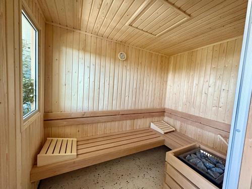 a wooden sauna with two benches and a window at Sweetly La Rochelle in La Rochelle