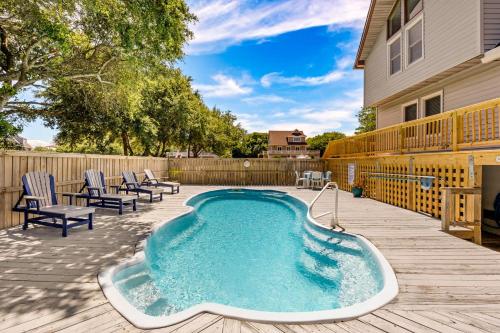 a swimming pool on a deck with chairs and a house at 4068 - Family Tradition in Kitty Hawk