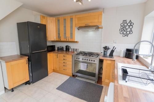 a kitchen with a stainless steel stove and wooden cabinets at Woodington House in Birmingham