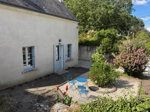 a house with a table and chairs in a yard at Gîte les Huttières in Cravant-les-Coteaux