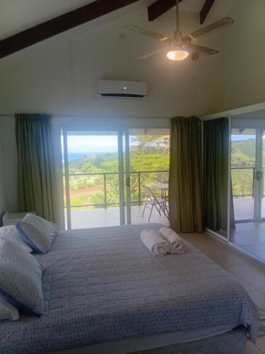 ein Schlafzimmer mit Bett und Balkon in der Unterkunft Sky view in Savusavu
