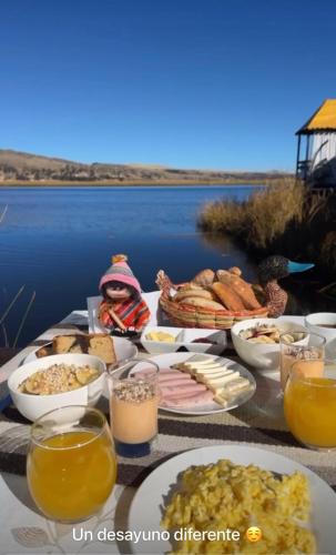a table full of food with a view of the water at KAY PACHA LODGE Uros in Puno