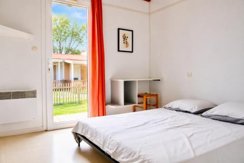 a bedroom with a bed and a sliding glass door at Chalet Mauzac- Piscine- Domaine Paisible in Rivières