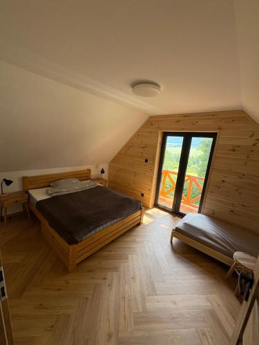 a bedroom with a bed and a large window at Lasóweczka in Lasowka