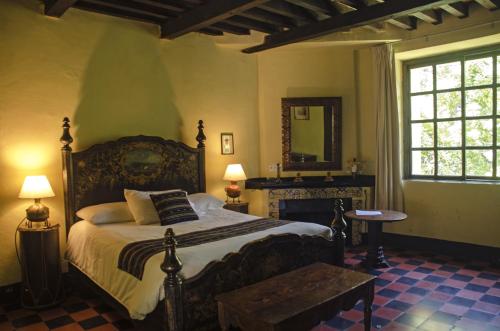 a bedroom with a large bed and a mirror at Hotel Museo Mayan Inn in Chichicastenango