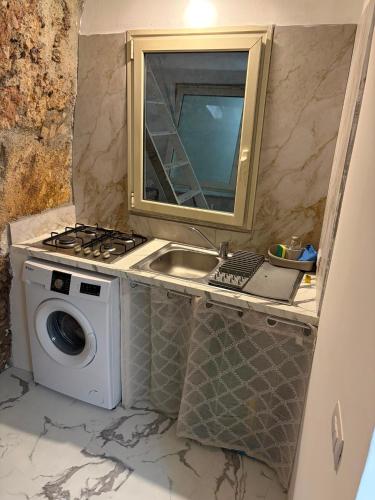 a kitchen with a sink and a washing machine at Casa Mediterraneo in Catania
