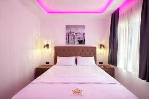 a bedroom with a bed with a purple ceiling at Villa President 2 in Kunjići