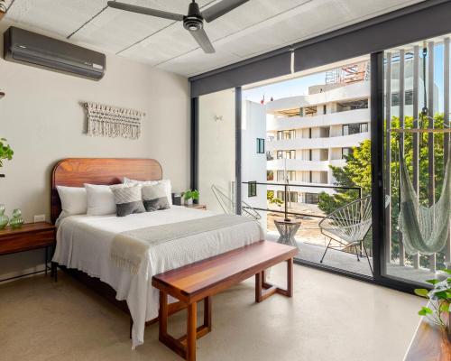 a bedroom with a bed and a large window at The Sands Boutique Condos in Playa del Carmen