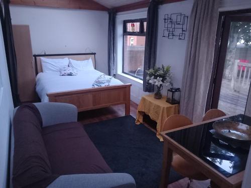 a bedroom with a bed and a couch and a window at Divis street guest house in Belfast