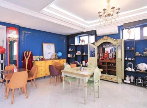 a dining room with blue walls and a table and chairs at NovArt Gallery Hotel in Sumqayıt