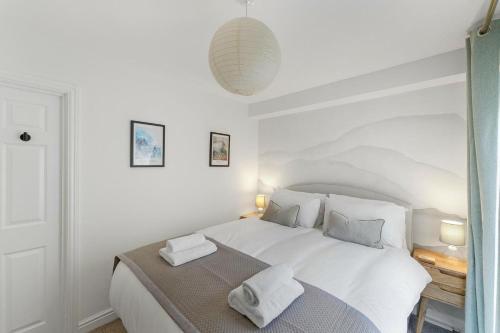 a bedroom with a white bed with two towels on it at 1 Bed in Windermere oc-lr189 in Windermere