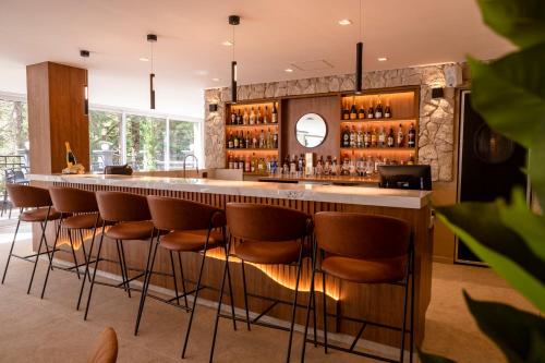 a bar with brown bar stools in a room at Champet Boutique Hotel in Campos do Jordão