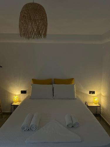 a bedroom with a white bed with two towels on it at Salty Rock - Kythnos Suite in Kithnos