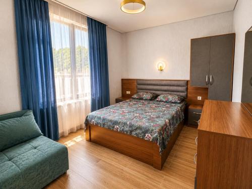 a bedroom with a bed and a couch and a table at Apollo Cottages Kaprovani in Urekis Sadguri