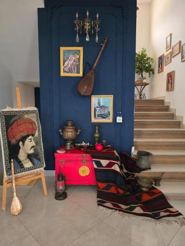 a room with a blue wall with a table and a guitar at NovArt Gallery Hotel in Sumqayıt