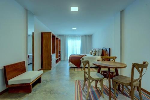a living room with a table and chairs and a couch at Cairé Suites in Itacaré