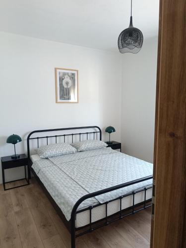 a bedroom with a bed and two lamps on tables at Apartment Hidden Garden in Pula
