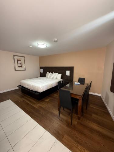 a bedroom with a bed and a desk and a table at Falls Lodge by the Falls (Formerly Knights Inn) in Niagara Falls
