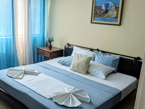 a bedroom with a bed with blue and white pillows at Beach-side condos at Turtle Beach Towers in Ocho Rios