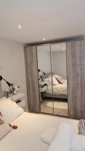a bedroom with a large mirror and a bed at The Dorking Hideaway B&B in Dorking