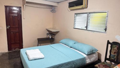 a small bedroom with a blue bed and a window at Cary's Studio in David