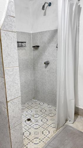a shower with a shower curtain in a bathroom at Cary's Studio in David