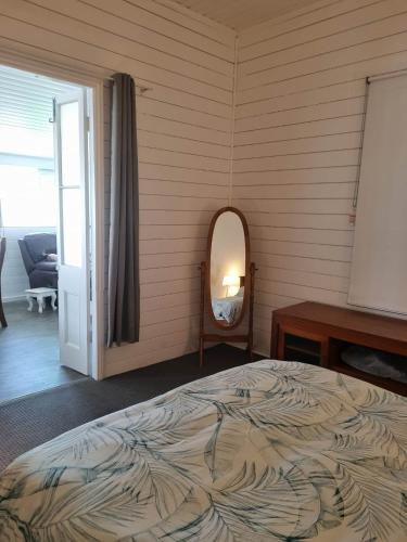 a bedroom with a bed and a mirror at Horseshoe House - Gympie in Gympie