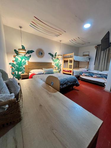 a large room with two beds and a table at Kinti Wasi Casa de Campo Hospedaje in Los Baños del Inca