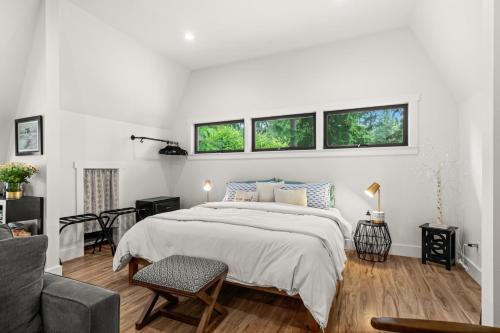a white bedroom with a bed and two windows at The Loft | Beach | Kayaks & Pickleball in Bremerton