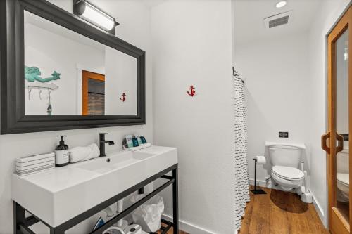 a bathroom with a sink and a mirror and a toilet at The Waterwheel in Bremerton