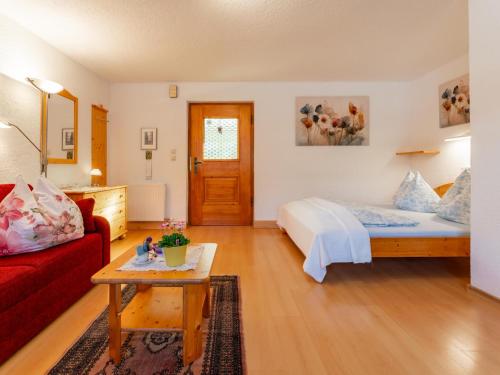 a bedroom with a bed and a red couch at Maria in Leogang