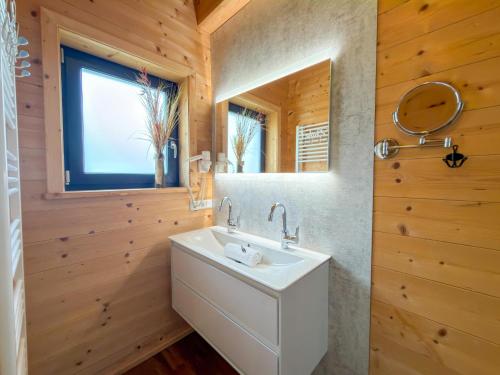 a bathroom with a white sink and a mirror at Rattendorf 5B in Rattendorf