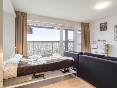 a bedroom with a bed and a couch and a window at B City Complex - 0209 in Blankenberge