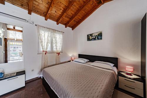 a bedroom with a bed and a window at Apartments by the sea Grscica, Korcula - 169 in Prizba