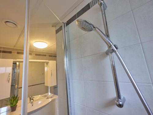 a shower with a shower head in a bathroom at t Kaatsheuveltje 9 in Kaatsheuvel