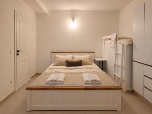a bedroom with a large bed with two towels on it at Apartmani EMMA in Kotor