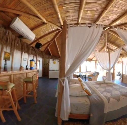 a bedroom with a bed with a wooden ceiling at Bora Bora Bungalows in Los Órganos