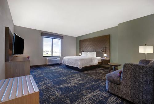 a hotel room with a bed and a chair at Hampton Inn Patterson, Ca in Patterson