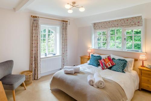 a bedroom with a bed and a chair and windows at 6 Bed in Haslemere oc-c34083 in Haslemere