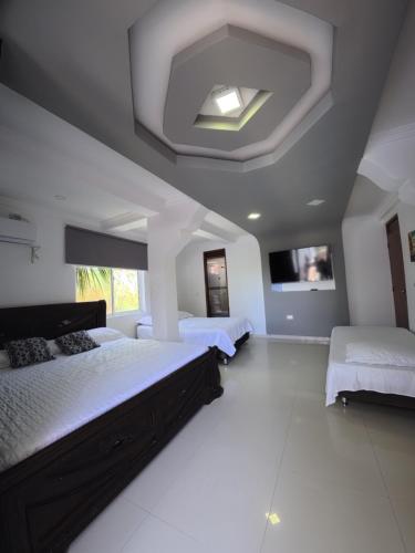 a large bedroom with two beds and a tv at Apartamentos Isla Tropical in San Andrés