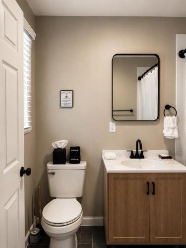 a bathroom with a white toilet and a sink at KC's Corner Motel in East Springfield