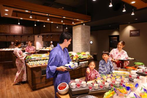 a group of people in a buffet line with food at Ooedo Onsen Monogatari Premium Atami in Atami