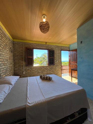 a large bed in a room with a window at Pousada Sol Nascente in Beberibe