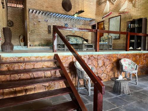 a staircase in a room with a counter and chairs at Pousada Sol Nascente in Beberibe
