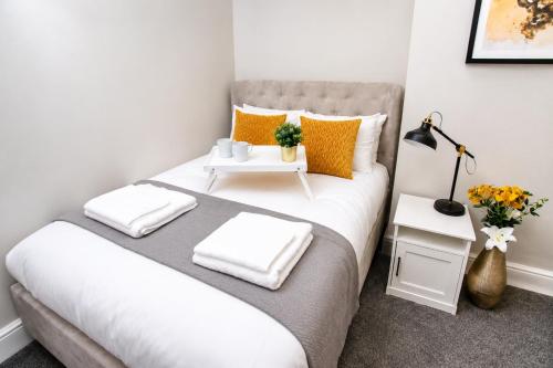 a bedroom with a large bed with orange and white pillows at City Centre 1 Bed Apartment - Modern & Bright in Chester