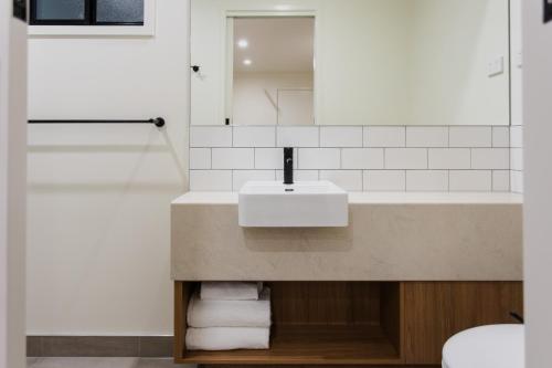 a bathroom with a sink and a mirror at Currimundi Hotel in Caloundra