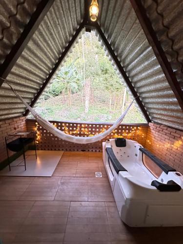 a room with a hammock in a attic at Chalé Suíco Nupcial II - Chalés Belo Monte - Pacoti in Pacoti